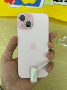 iPhone 15 rosa na mão de um a pessoa na loja