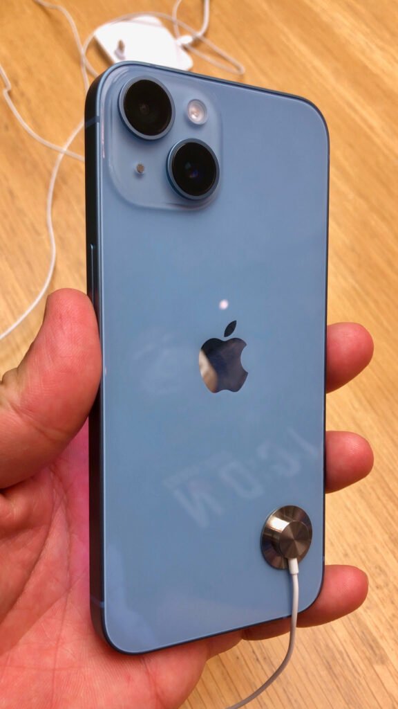 iPhone 14 sendo segurado em loja