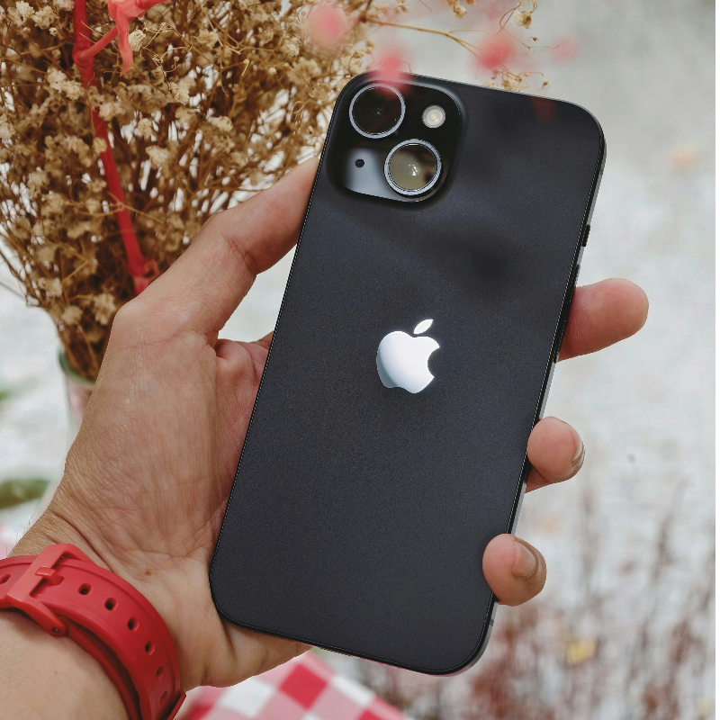 iPhone 15 sendo segurado na mão ao ar livre