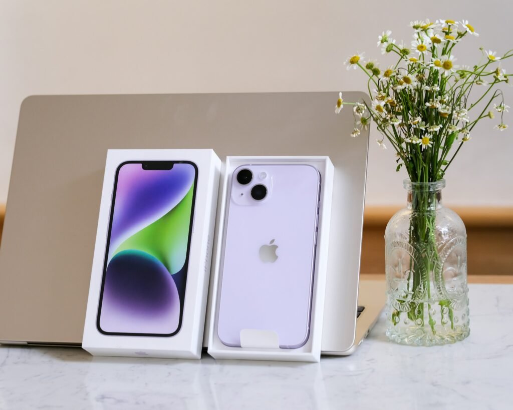 iPhone 14 sobre a mesa encostado em um macbook